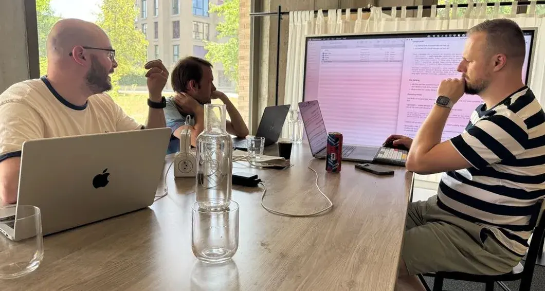 Drei Previon-Mitarbeiter arbeiten mit Laptops an einem Sitzungstisch, ein Dokument ist auf dem Bildschirm gespiegelt
