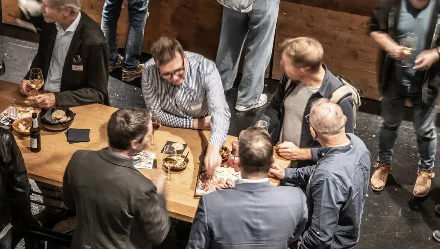 Gast greift in das Aperoplättchen in der Aeschbachhalle aus der Vogelperspektive