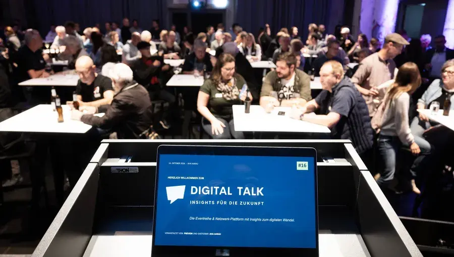 Laptop auf der Bühne stehend vor einer voll bestuhlten Aeschbachhalle